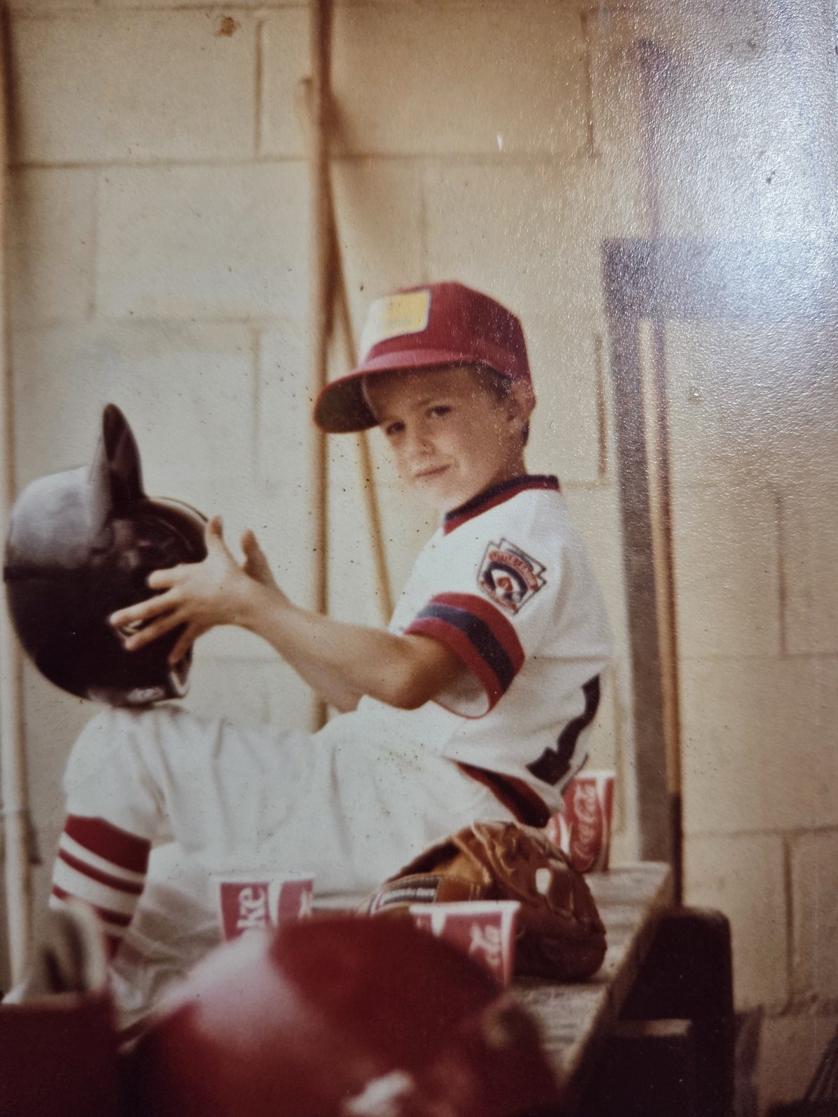 Michael Karl McNeil in a Little League uniform in the dugout